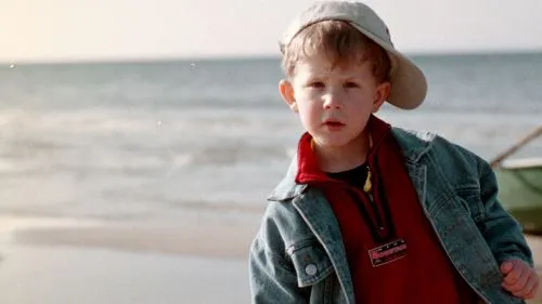 Dziecko w czapce i kurtce na plaży