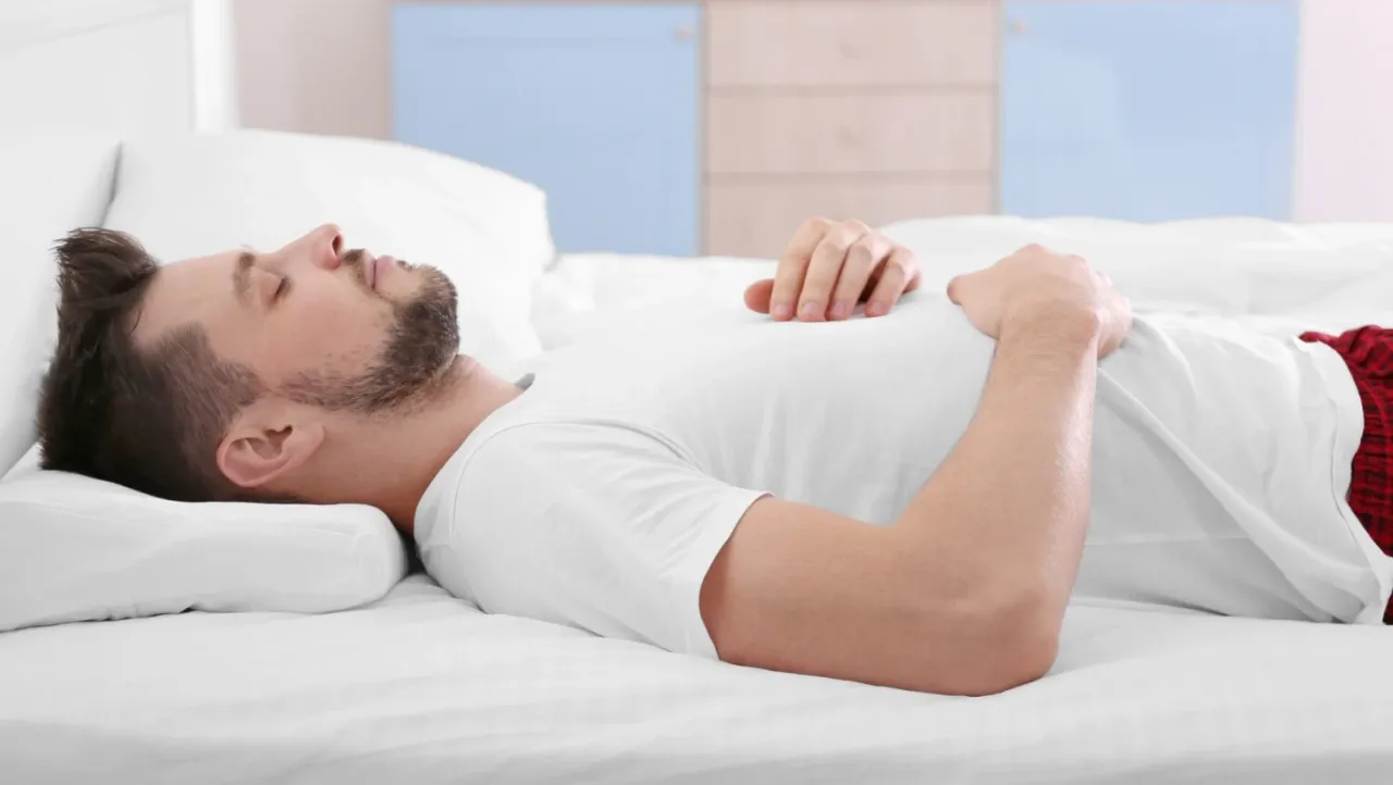 Mężczyzna śpiący spokojnie na plecach