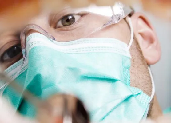 pacjent w maseczce w poczekalni u dentysty