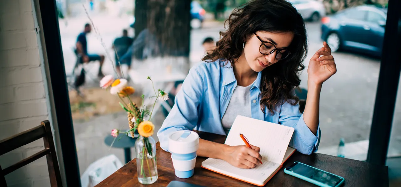 osoba pisząca w dzienniku, wyznaczająca cele, małe kroki, wizualizacja sukcesu