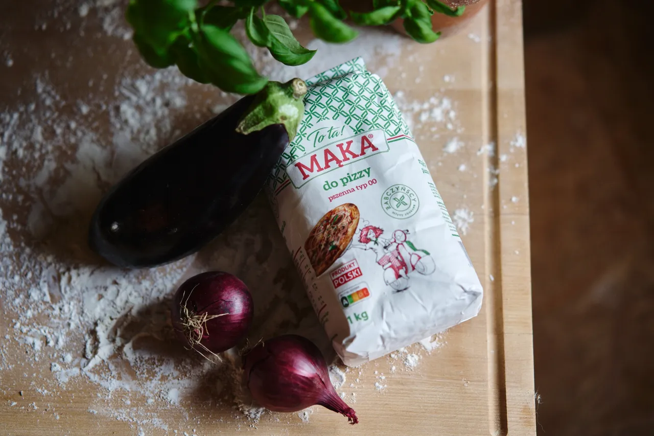Mąka do pizzy pszenna typ 00, bakłażan i cebula na desce, gotowe do przygotowania włoskiego przysmaku.