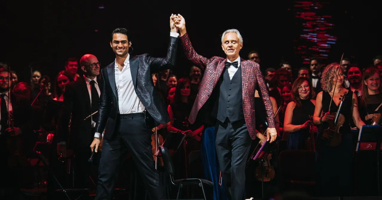 Andrea Bocelli i Matteo Bocelli na scenie, gdzie odbył się koncert Bocellego w Warszawie. Orkiestra i chór w tle.