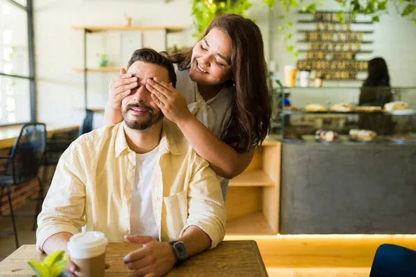 Dziewczyna uśmiechająca się do chłopaka w kawiarni