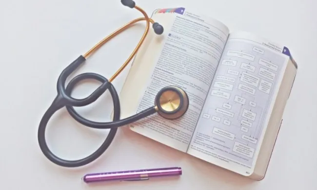 przybory medyczne studenta: stetoskop, fartuch, podręczniki