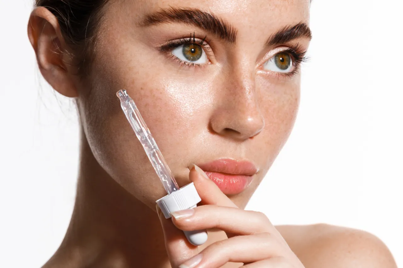 Kobieta analizująca etykietę kosmetyku z kwasem salicylowym