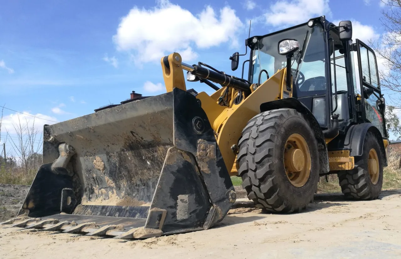 Ż&oacute;łta ładowarka na budowie. Zastanawiasz się, ile zarabia operator koparki?