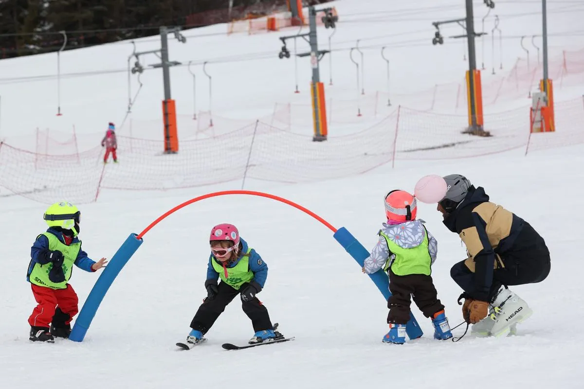 Dzieci uczące się jeździć na nartach w Beskidach