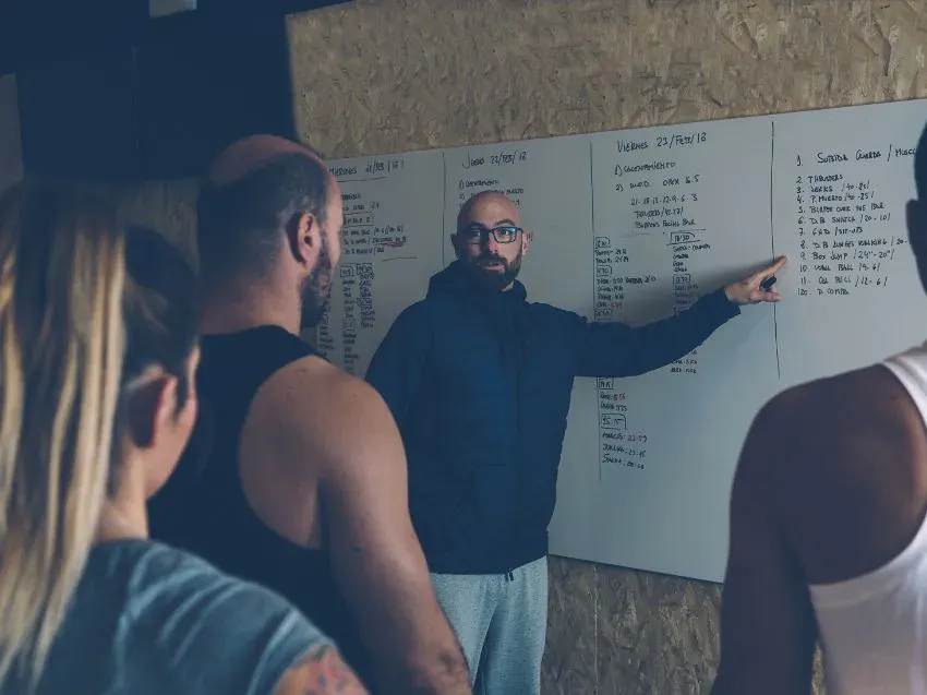 Trening CrossFit, widoczny WOD na tablicy