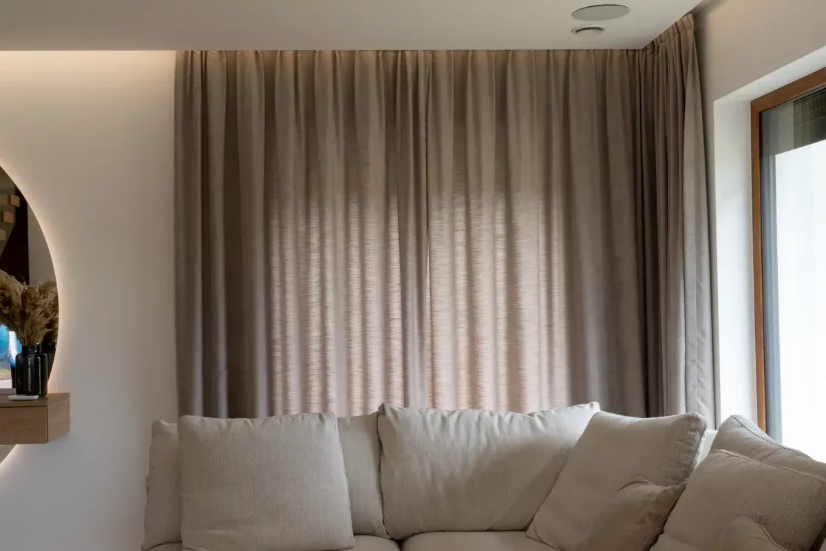 Zasłony do beżowych ścian i szarej kanapy neutralne kolory
