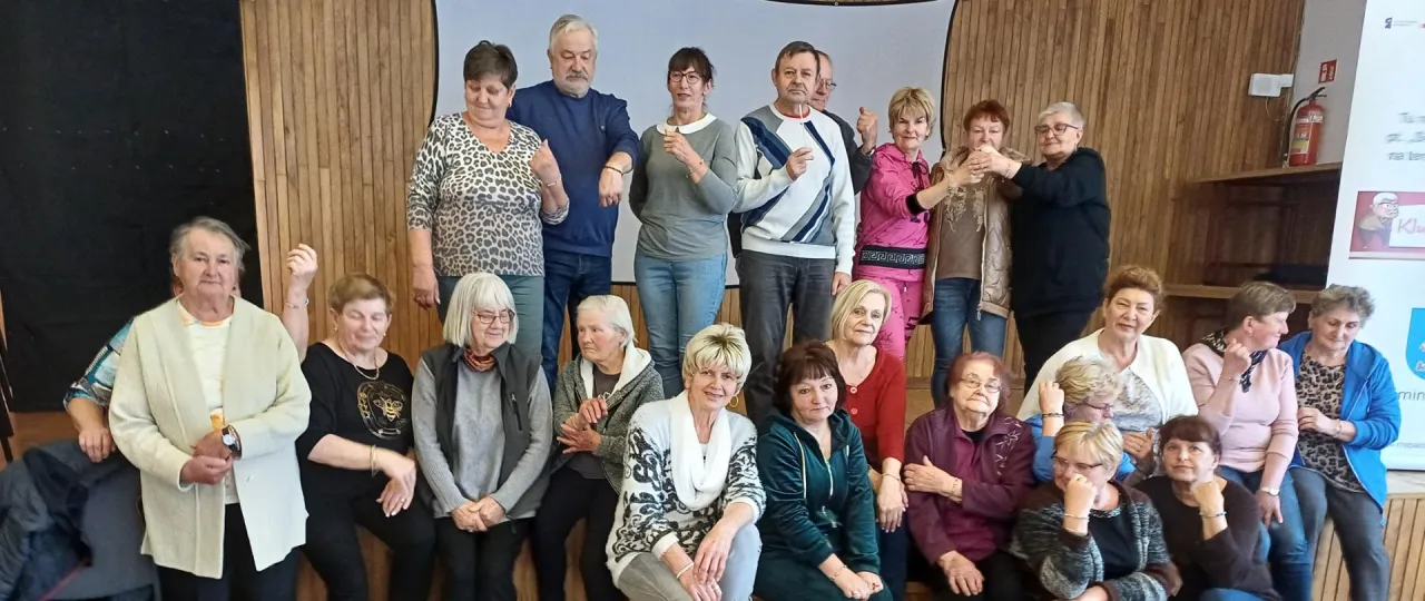 Grupa senior&oacute;w, kt&oacute;rzy uczą się, jak założyć klub seniora. Wszyscy uśmiechnięci i gotowi do działania.
