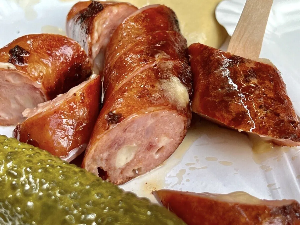 Sycąca kiełbaska z serem i ogórkiem, idealna odpowiedź na pytanie gdzie zjesc w Wiedniu tanio.