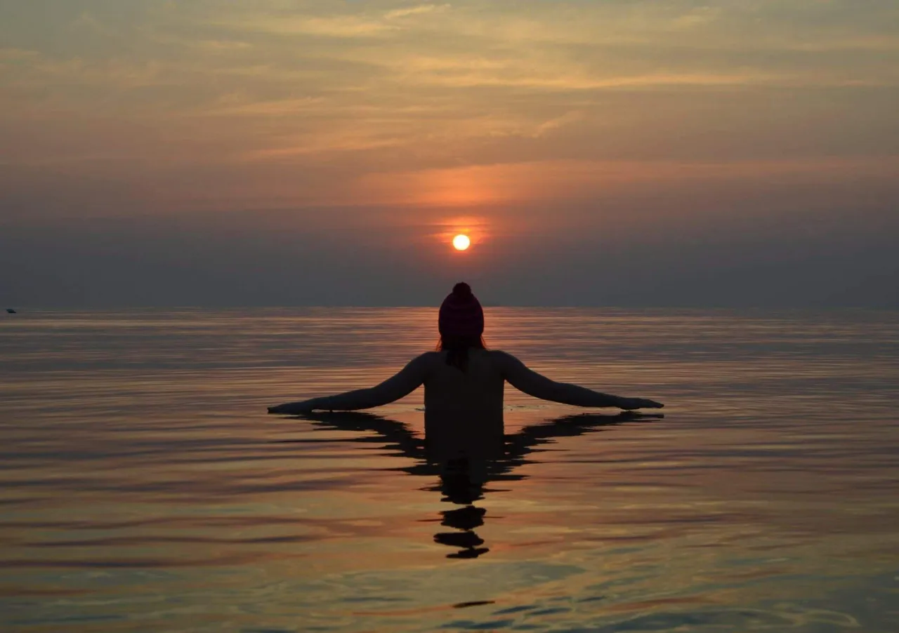 Osoba medytująca przy wschodzie słońca