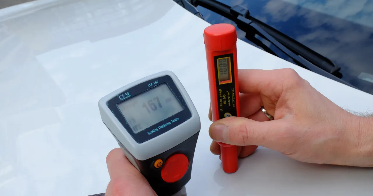 osoba sprawdzająca lakier samochodu miernikiem grubości