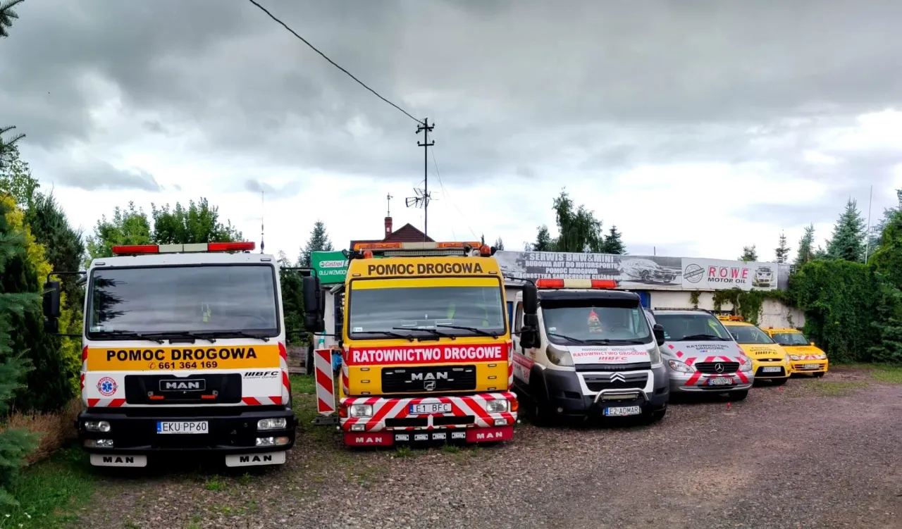Flota pojazd&oacute;w do holowania na autostradzie: biały i ż&oacute;łty MAN, biały bus i dwa ż&oacute;łte samochody.