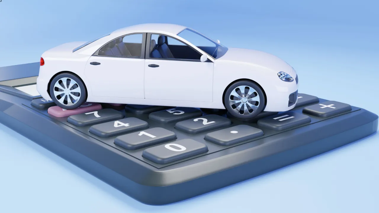 Biały samoch&oacute;d na kalkulatorze symbolizuje auta tanie w utrzymaniu.