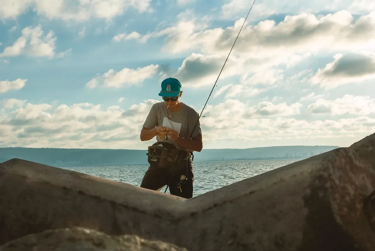 Wędkarz przygotowuje się do łowienia, zastanawiając się, jaka zanęta na leszcza będzie najlepsza.