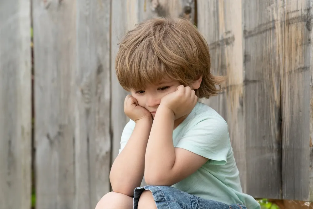dziecko smutne zamyślone, dziecko wycofane, dziecko z problemami w szkole