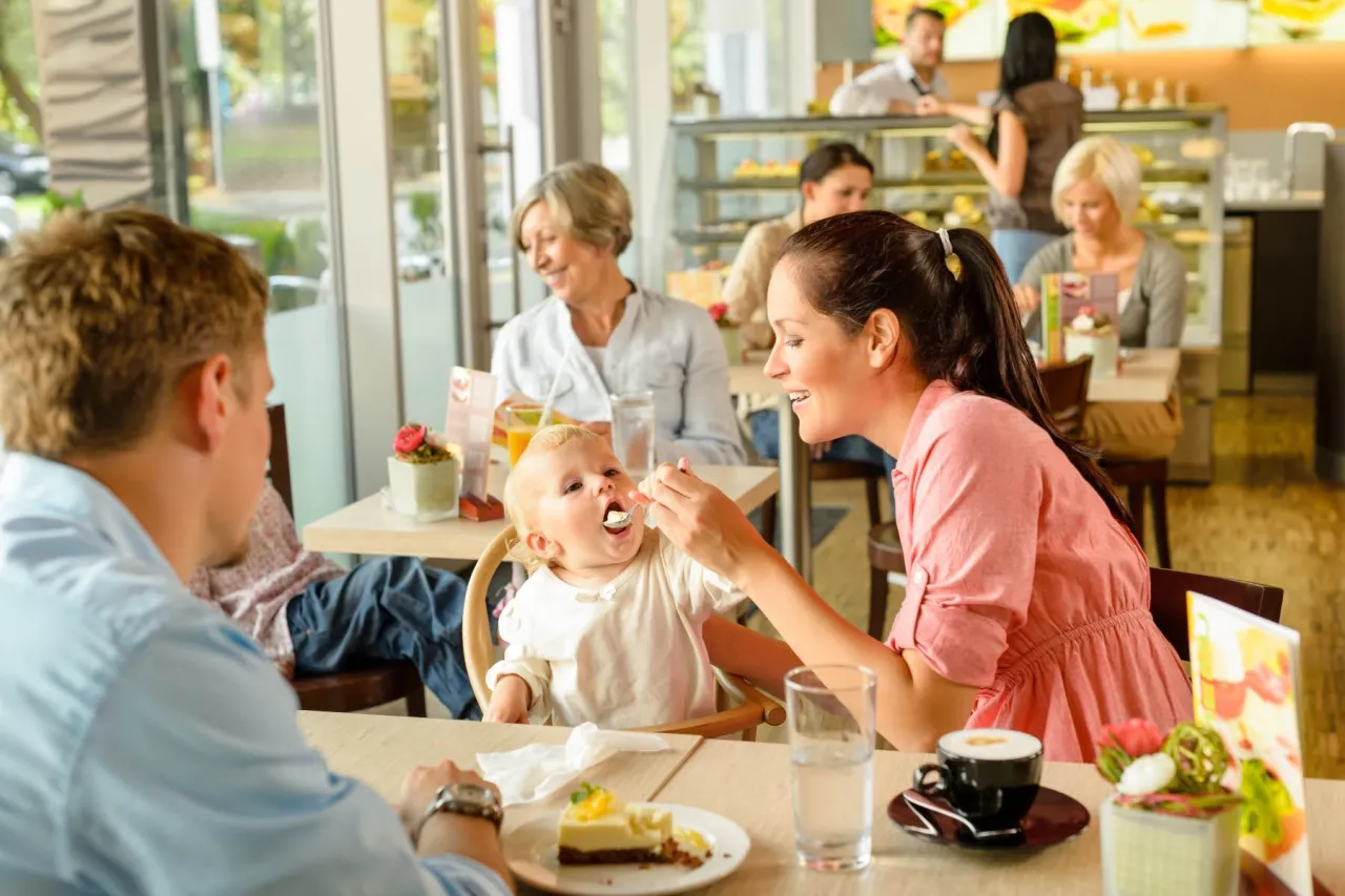 Familie isst in einem Restaurant mit Spielplatz