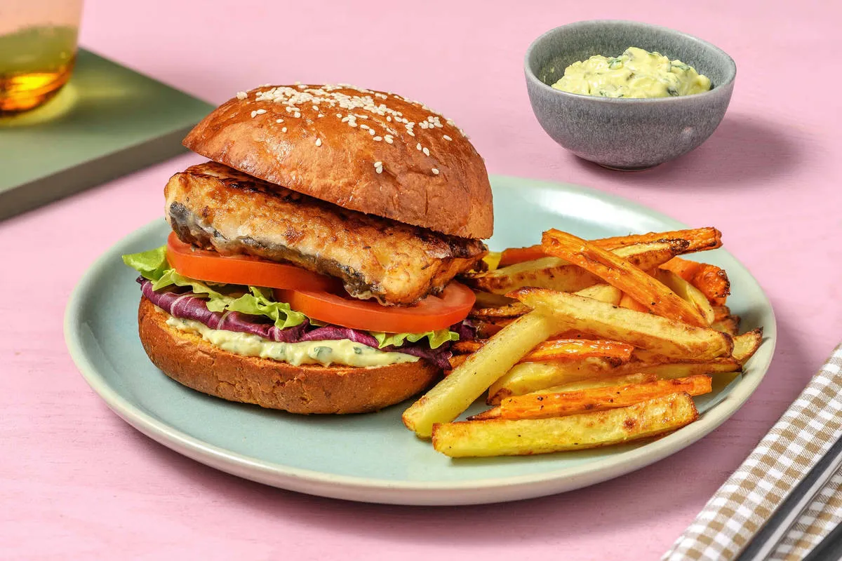 burger de poisson servi avec frites de patate douce et coleslaw sur une assiette