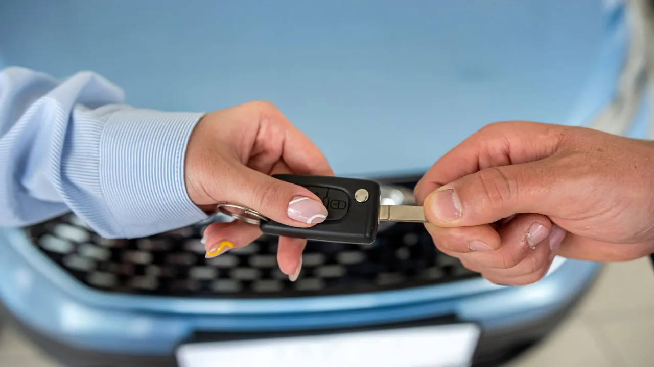 Przekazanie kluczyków do samochodu, symbolizujące rozwiązanie umowy leasingu przed upływem 2 lat.
