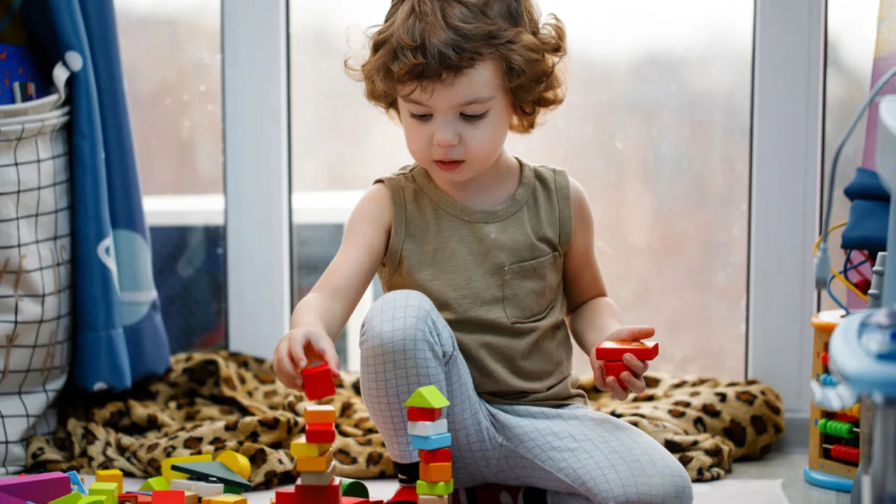 Dziecko z autyzmem bawi się w uporządkowanej przestrzeni