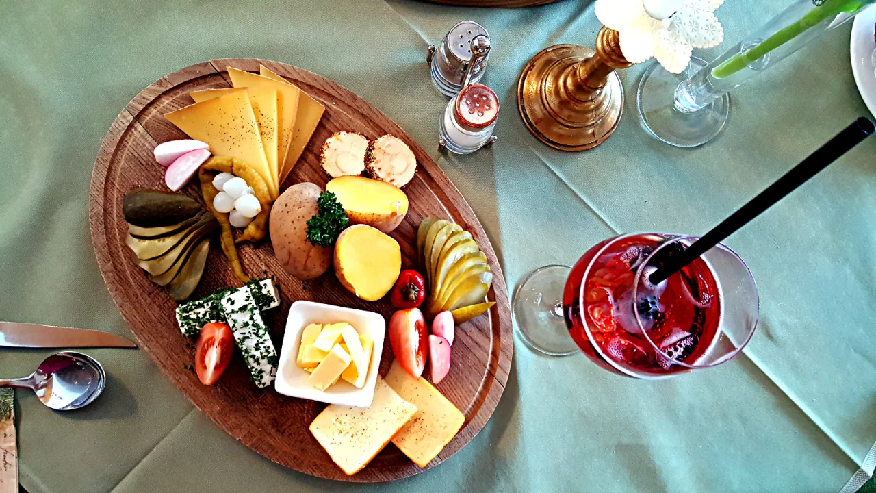 Pyszna deska serów, ziemniaków i pikli – idealne, co przywieźć z Austrii do jedzenia. Do tego czerwony napój z owocami.