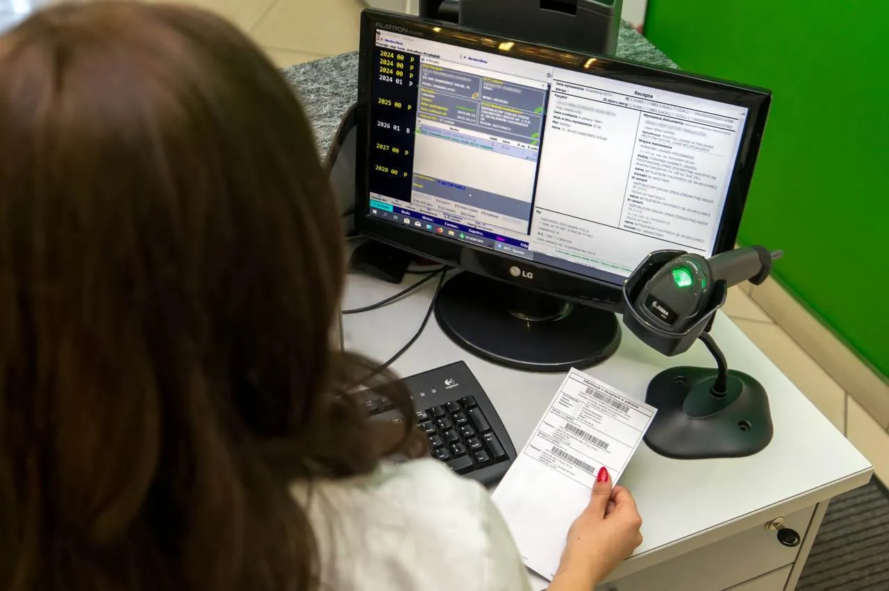 Farmaceuta korygujący e-receptę na komputerze, apteka