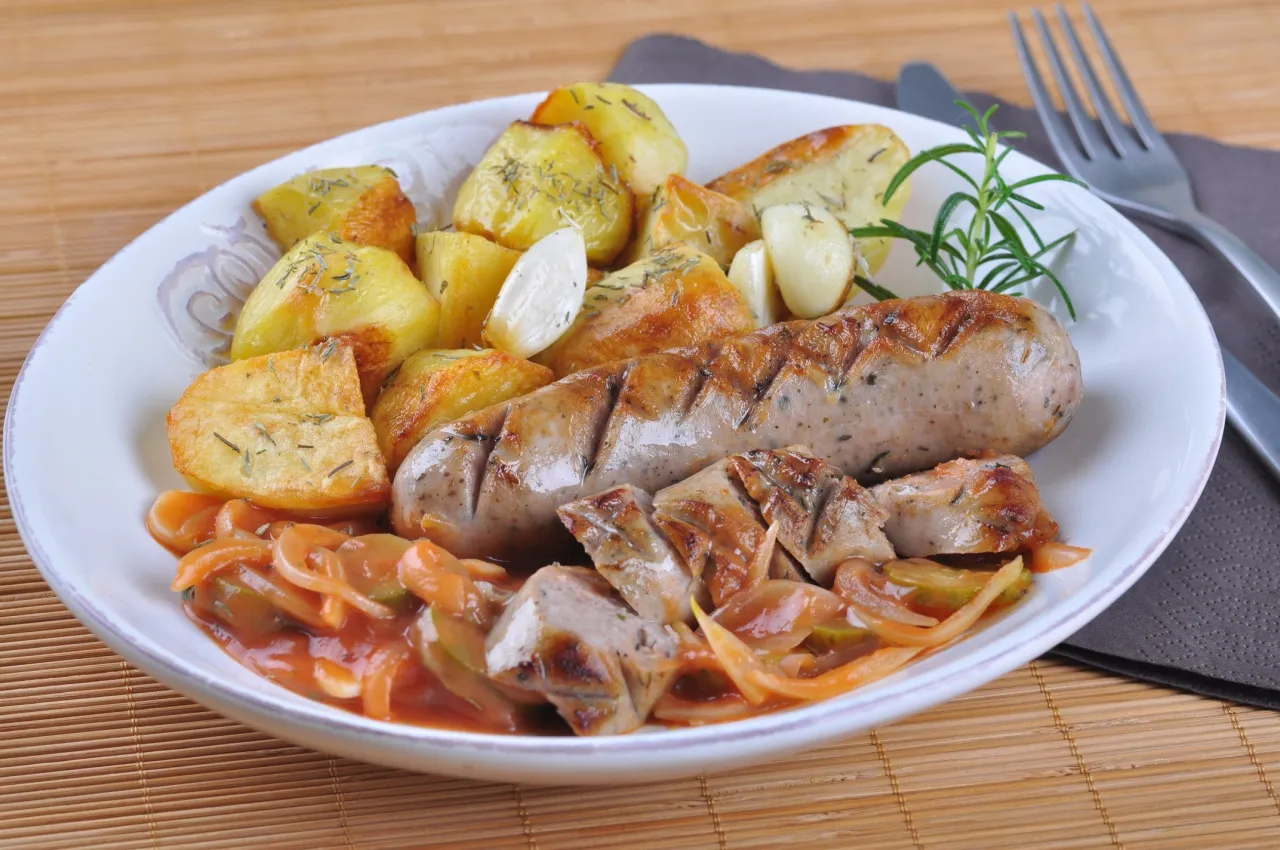 Talerz z grillowaną białą kiełbasą i dodatkami