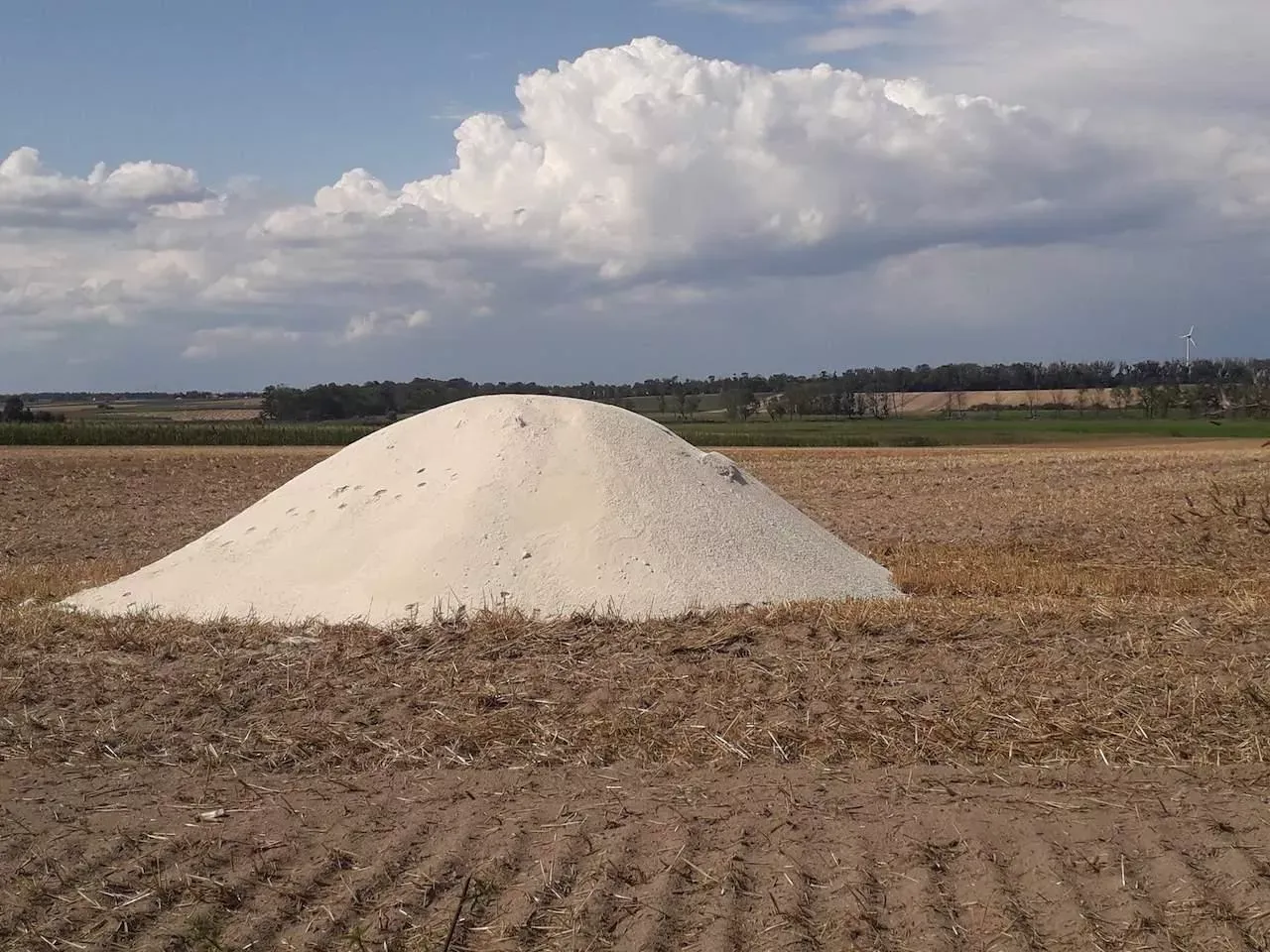 Kopiec białego wapna na polu, idealny do rekultywacji gleby. Zastanawiasz się, jakie wapno na dofinansowanie?