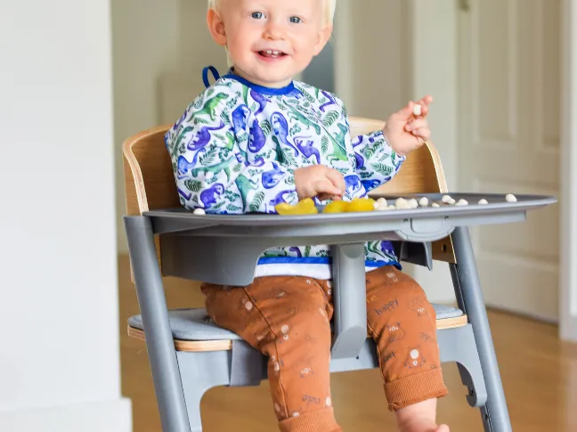 dziecko w krzesełku rosnącym z prawidłową postawą