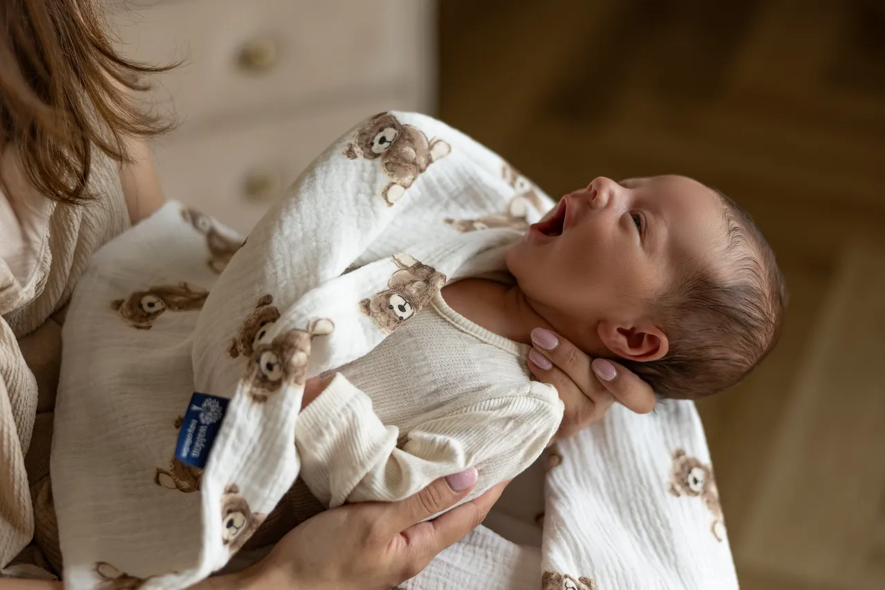 Noworodek otulony pieluszką muślinową
