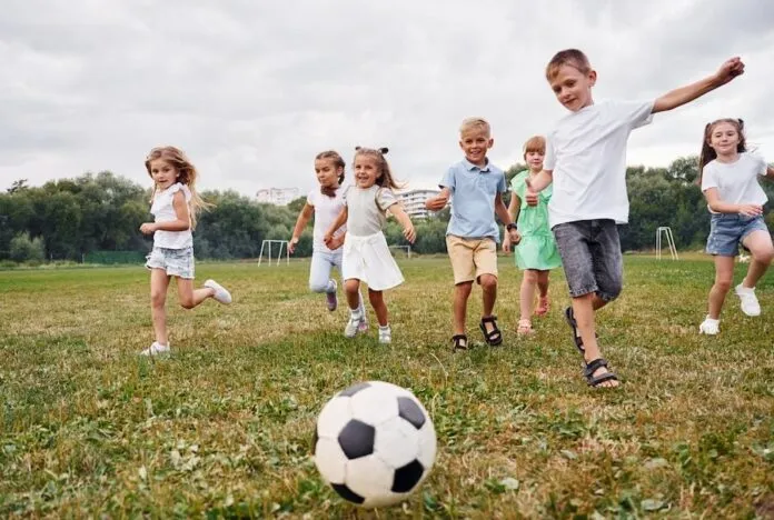 dzieci grające w piłkę nożną w różnym wieku