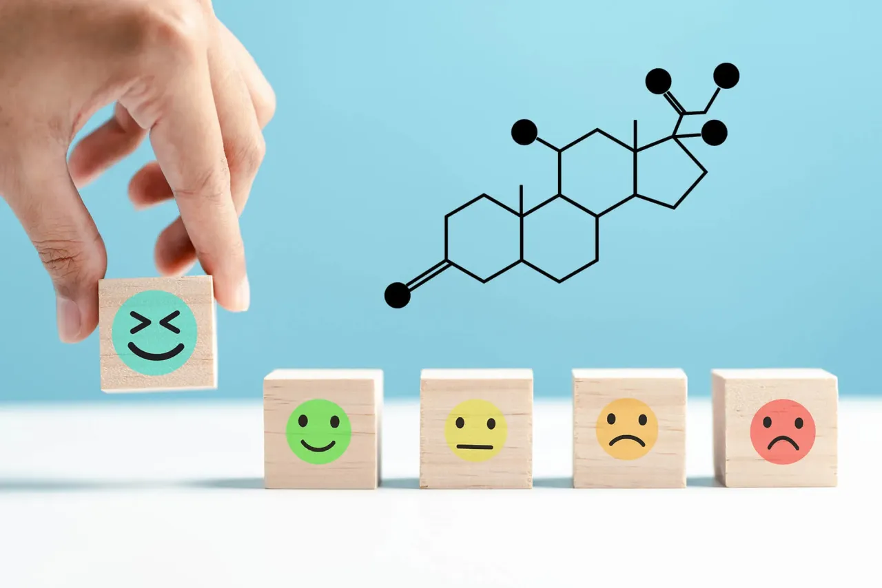 Badanie kortyzolu co to jest? Dłoń układa kostki z emotikonami, obok wzór chemiczny hormonu stresu.