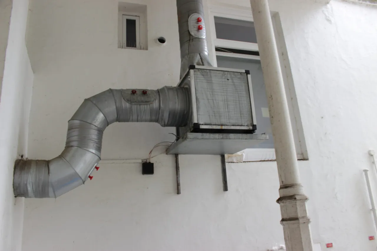 Laute Klimaanlage oder L&uuml;ftungsanlage an einer Hauswand eines Restaurants