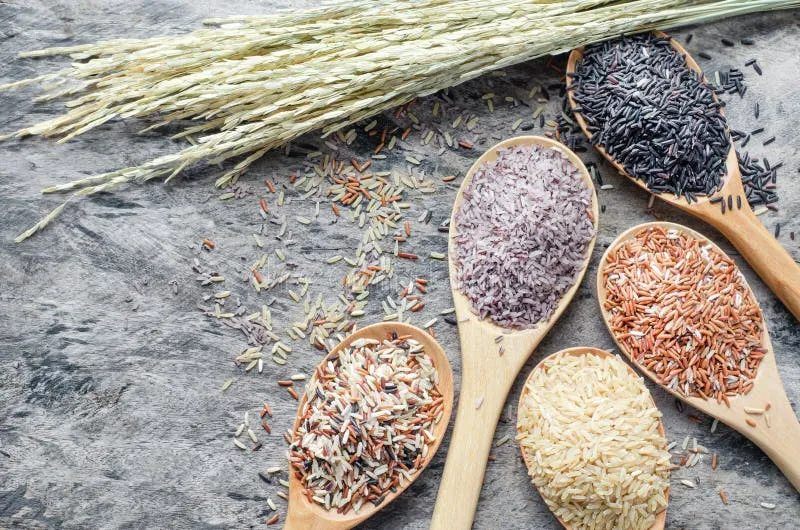 r&oacute;żne rodzaje ryżu na drewnianej łyżce