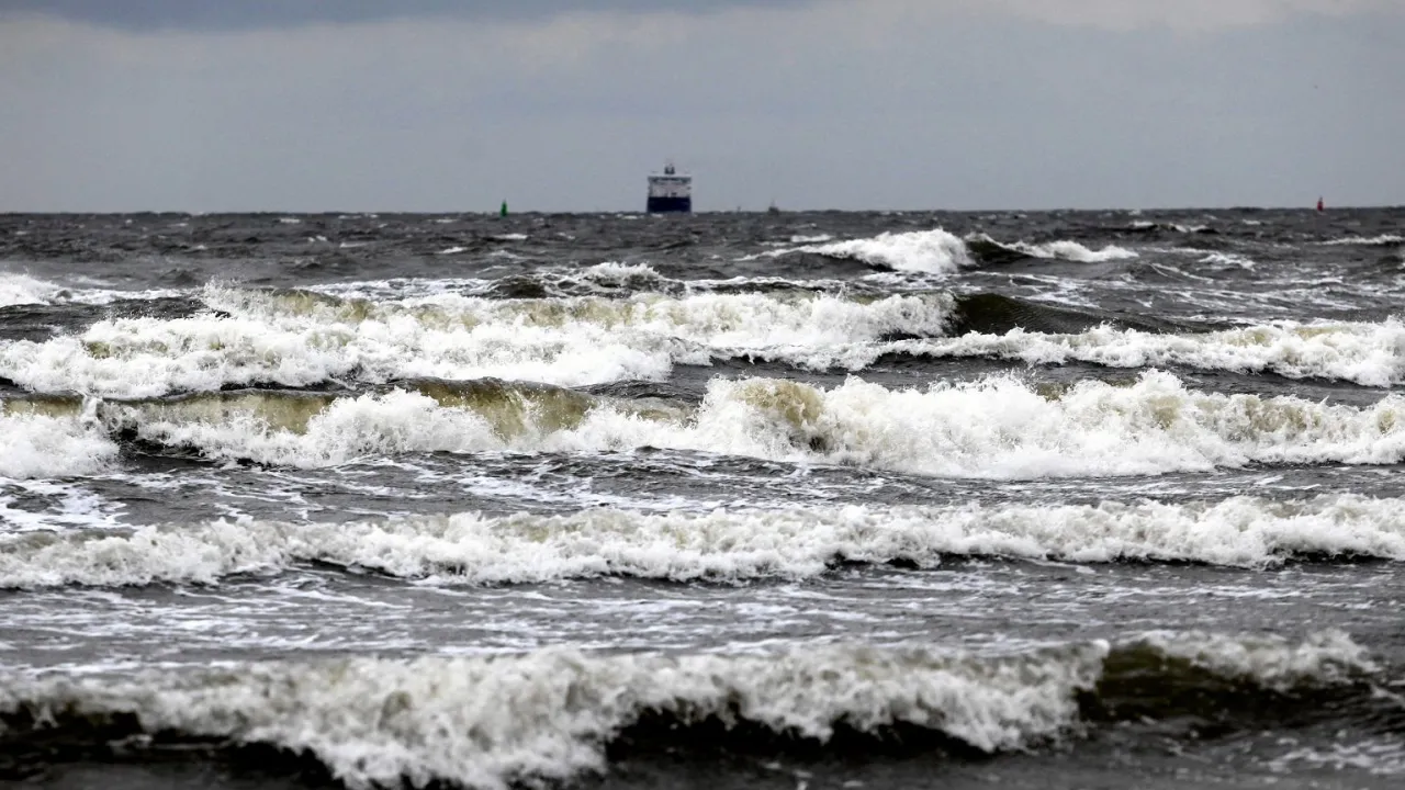 Wzburzone fale Bałtyku, ciemne niebo zapowiada, kiedy będzie sztorm. W oddali widać statek.
