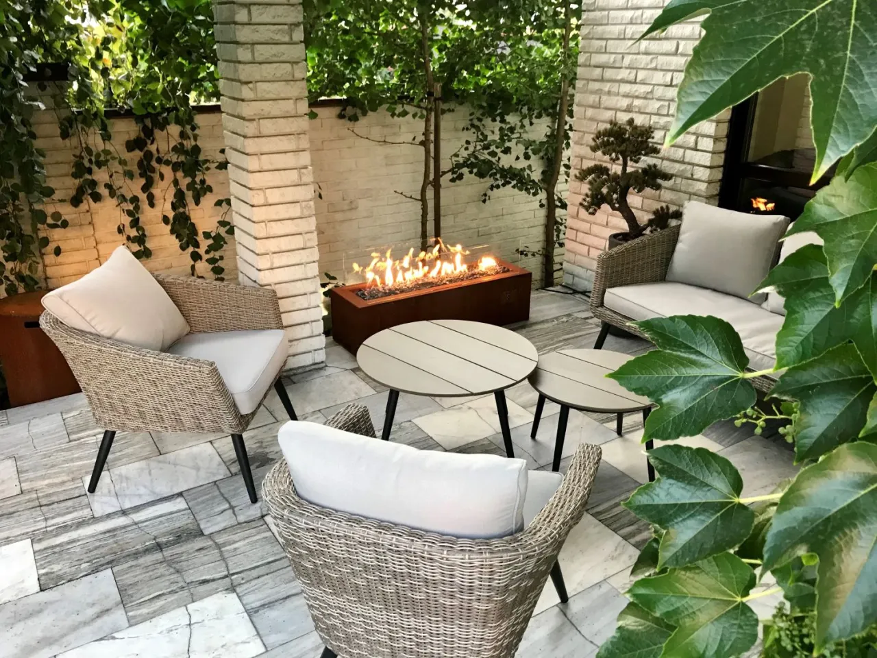 Nowoczesna pergola z paleniskiem gazowym. Wygodne fotele i stoliki tworzą idealne miejsce do relaksu. Jak postawić krb w pergoli?