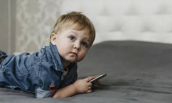 dziecko zamyślone z telefonem