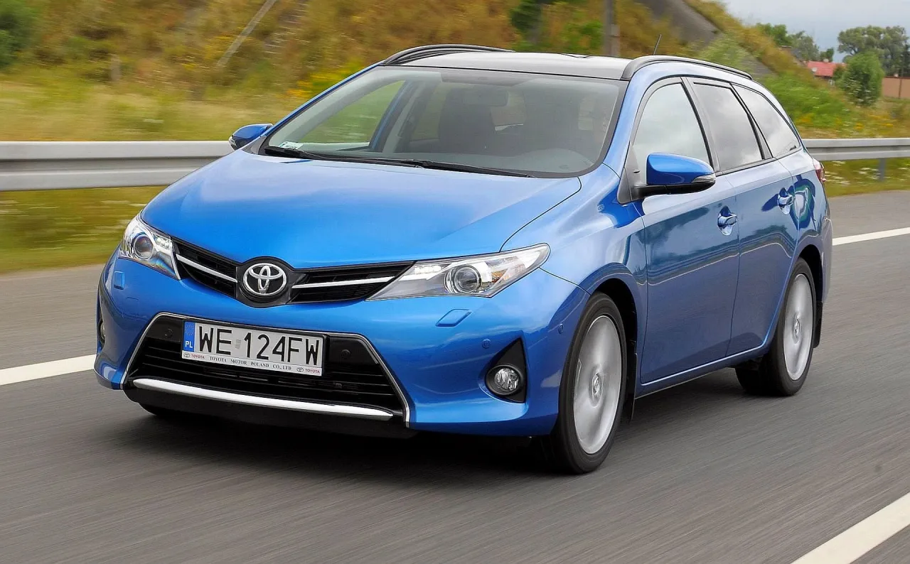 Niebieski kombi Toyota Auris jedzie po drodze. Czy to lepszy wyb&oacute;r niż Prius?