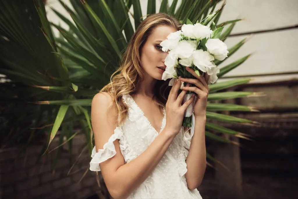 Panna Młoda w białej sukni i goście w kolorowych strojach