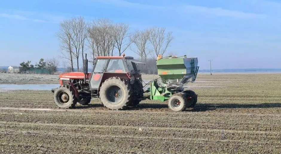 Rolnik na polu z nawozami lub maszynami rolniczymi