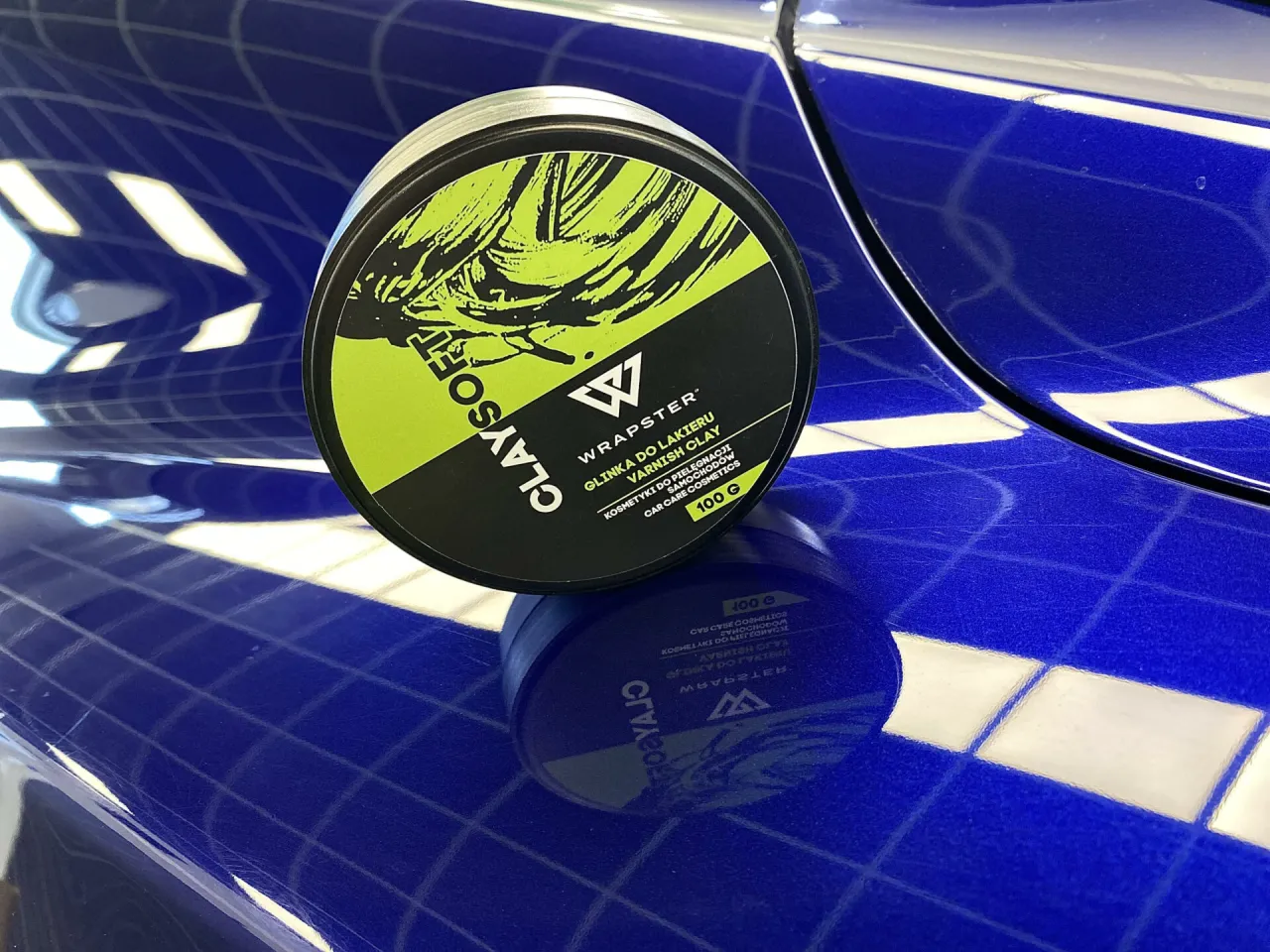Glinka do lakieru Wrapster ClaySoft na niebieskim, lśniącym tle. Idealna do przygotowania powierzchni przed polerowaniem.