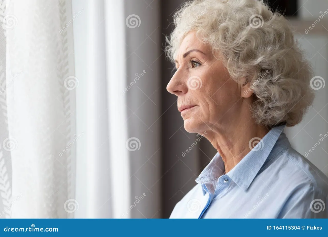 starsza osoba zamyślona patrząca przez okno