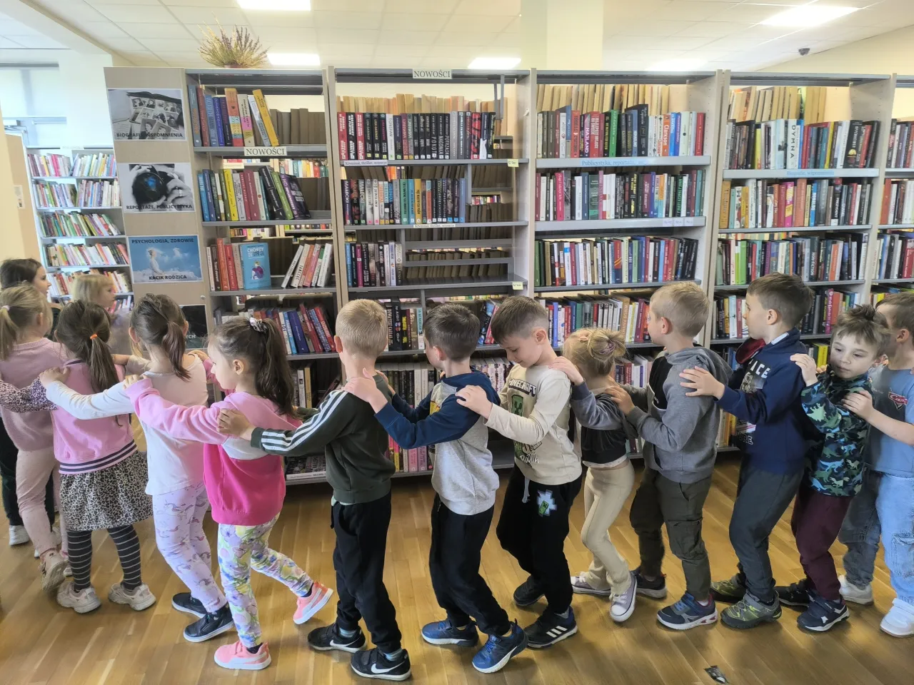 dzieci bawiące się w bibliotece z książkami