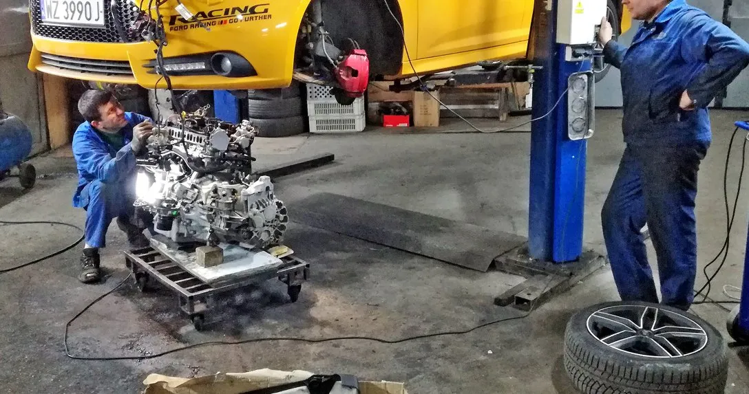 mechanik wymienia silnik, swap silnika w warsztacie