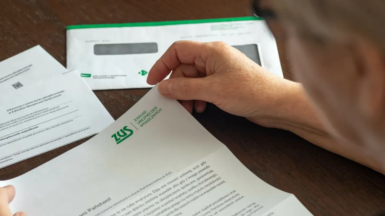 Dłoń przegląda dokumenty ZUS. Ile można chorować przed emeryturą? Pytanie o świadczenia i przyszłość.