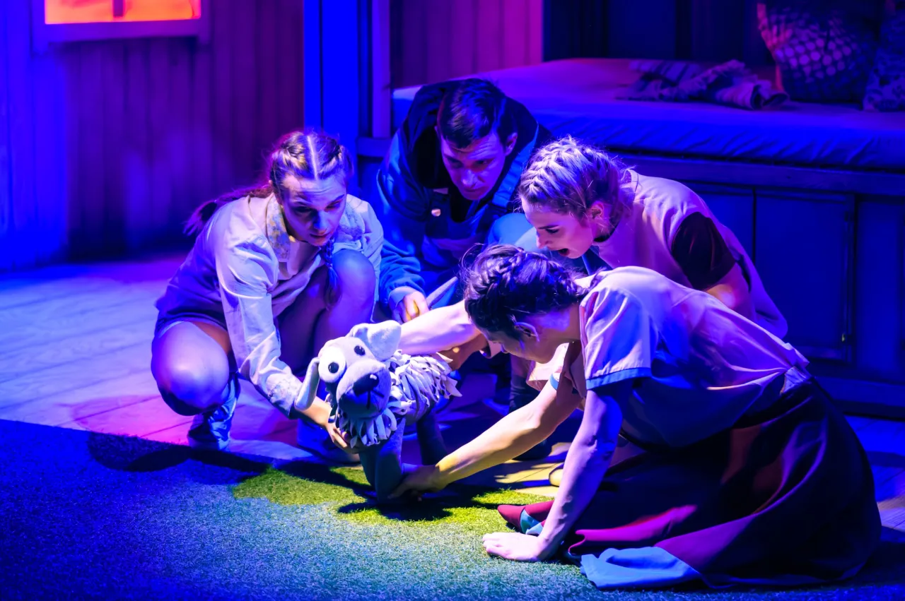 Aktorzy ożywiają pluszowego pieska podczas przedstawienia teatralnego dla dzieci.