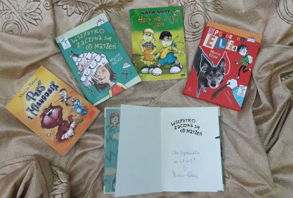 Autor książek dla dzieci podpisujący książki na spotkaniu