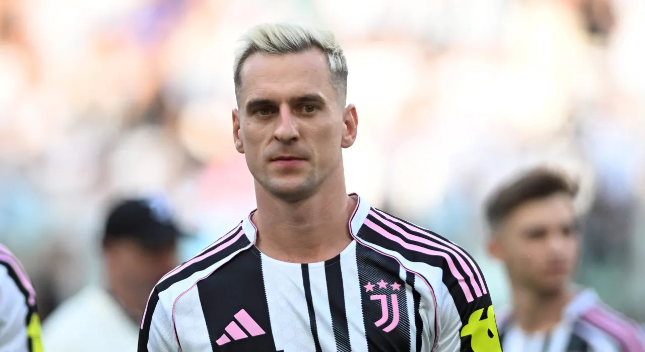 Piłkarz Juventusu z blond włosami w koszulce w pasy. Ciekawe, ile zarabia Milik, grając w tak prestiżowym klubie.