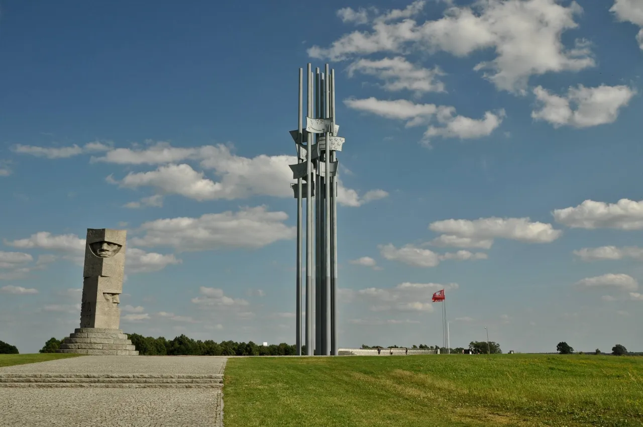 Pomnik Grunwaldzki, symbolizujący miejsce, gdzie leży Grunwald na mapie Polski, na tle błękitnego nieba z chmurami.